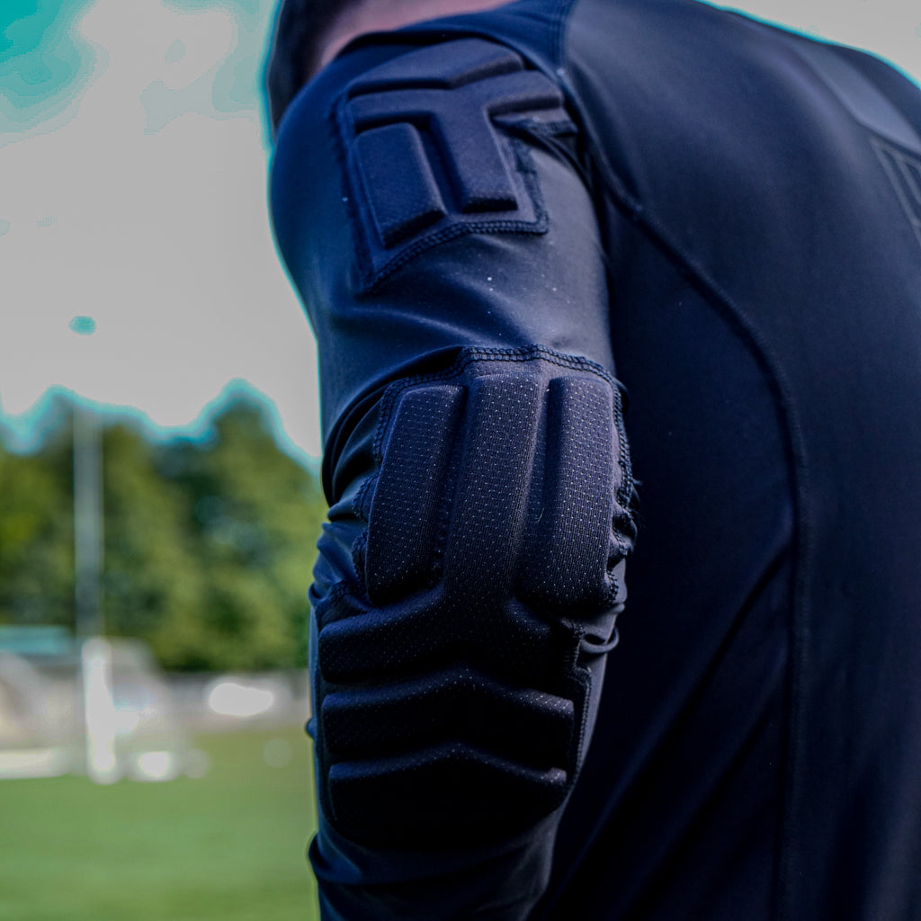 Kyynärpää-, kainalo-, selkä- ja olkapehmusteet JUNIOR POWER ARMOUR paidassa.